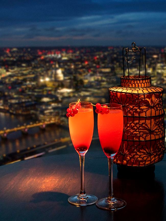 Two cocktails on a table with a London skyline view