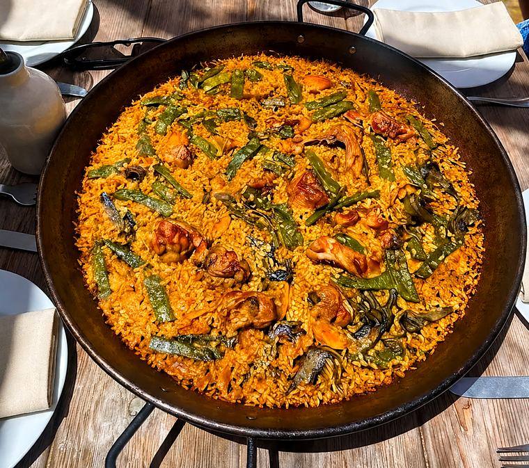 Traditional Spanish paella, cooked over fire and served family-style