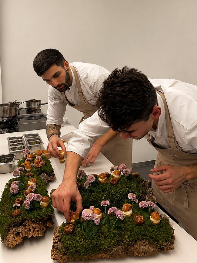 Two chefs finishing a floral petit four display